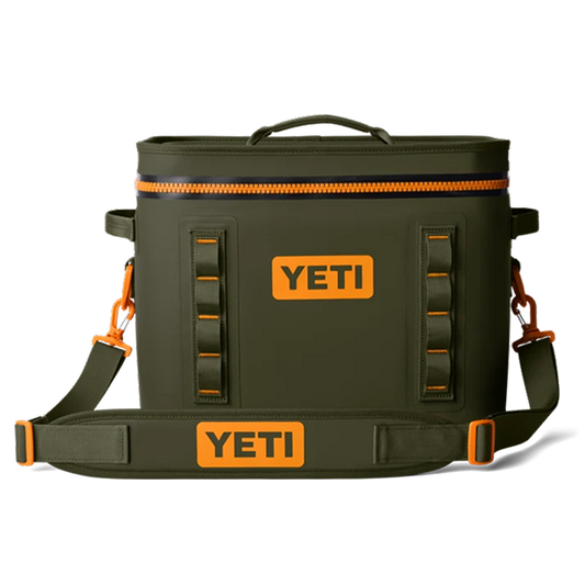 An olive green YETI cooler bag with bright orange accents, including zippers, buckles, and logo patches, shown against a plain white background.